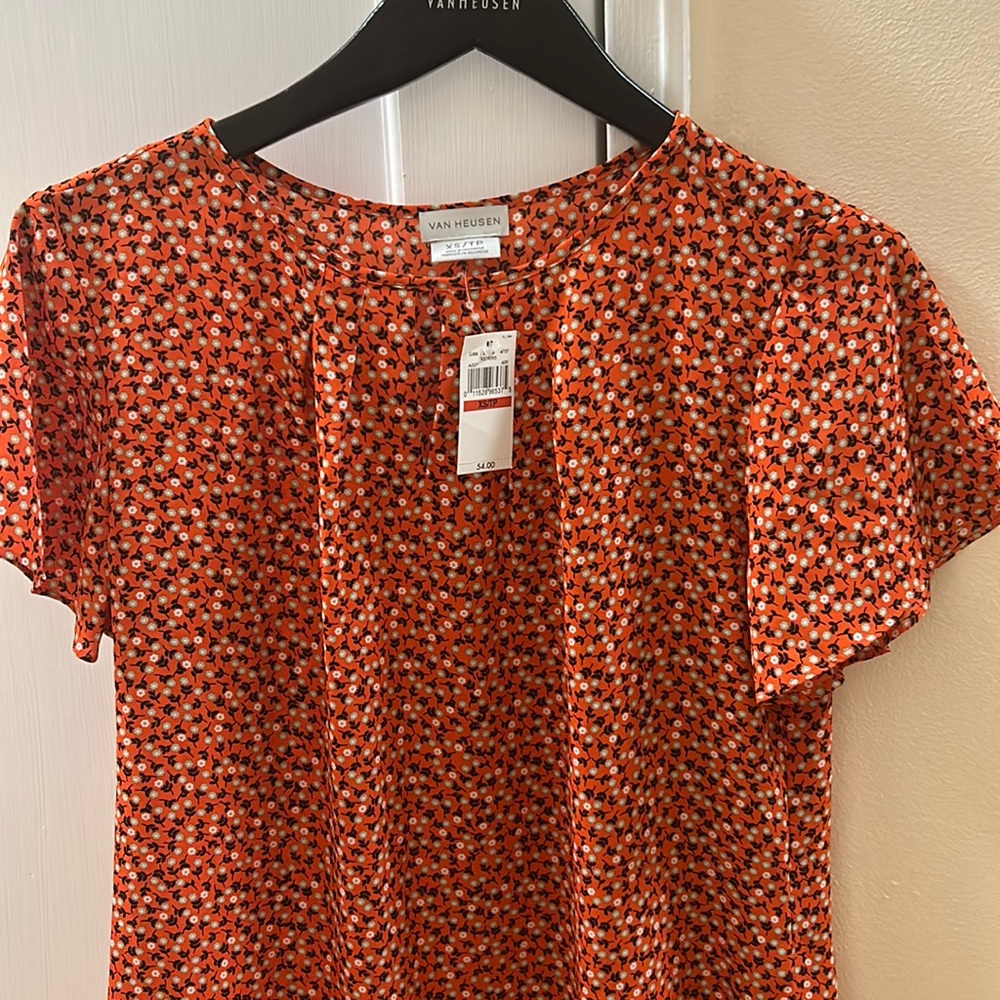 Spring floral blouse with light green and white flowers and orange background